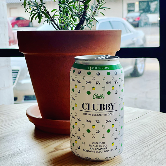 a can of beer sitting next to a potted plant